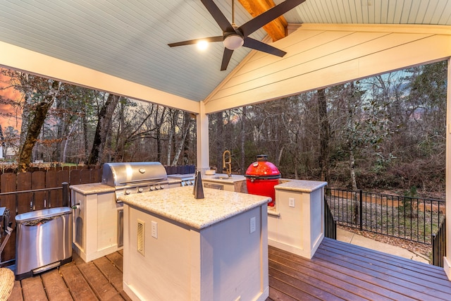 wooden deck with ceiling fan, an outdoor kitchen, a grill, and sink