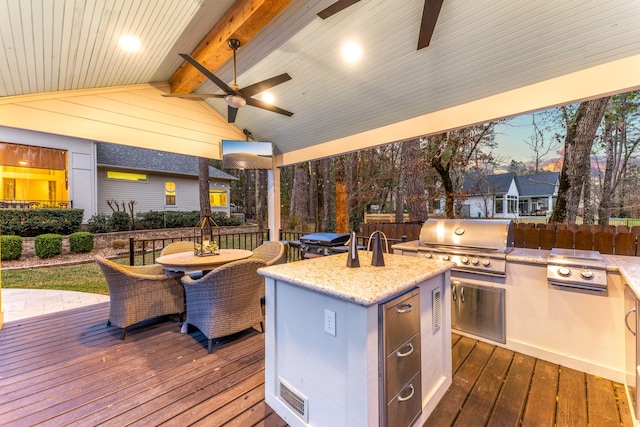 deck at dusk featuring ceiling fan, area for grilling, and grilling area