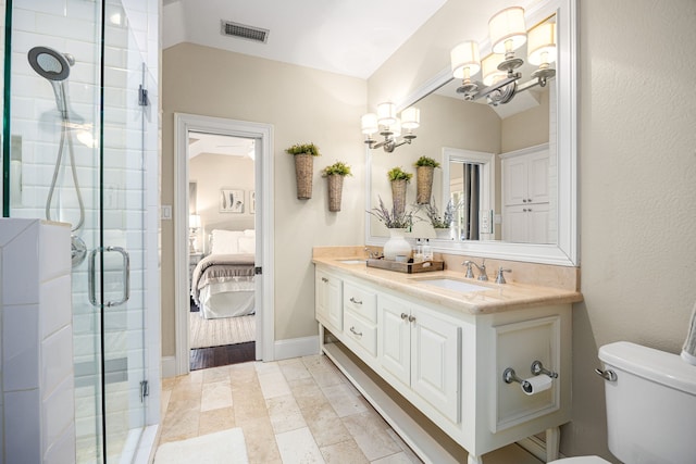 bathroom with vanity, toilet, a shower with door, and a notable chandelier