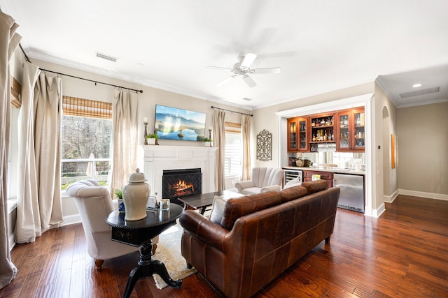 living room with a healthy amount of sunlight, dark hardwood / wood-style floors, and crown molding