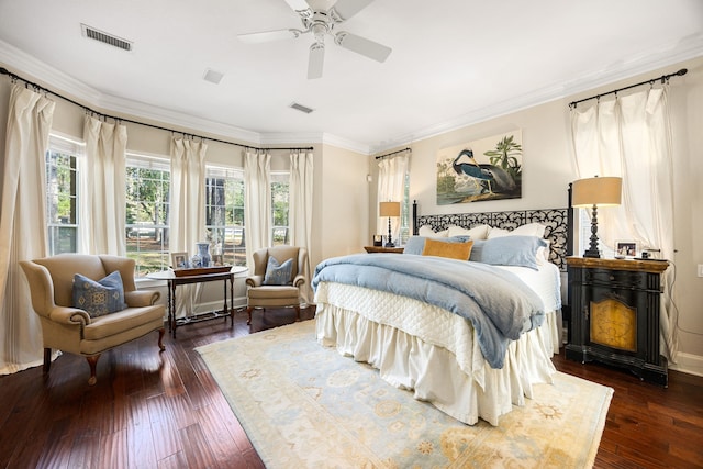 bedroom with ornamental molding, dark wood-type flooring, and ceiling fan