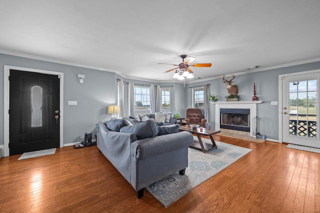 living room featuring hardwood / wood-style flooring, a healthy amount of sunlight, and crown molding