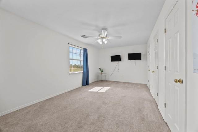 spare room with light colored carpet and ceiling fan