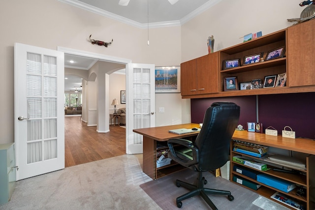 carpeted office space with ornamental molding and a towering ceiling