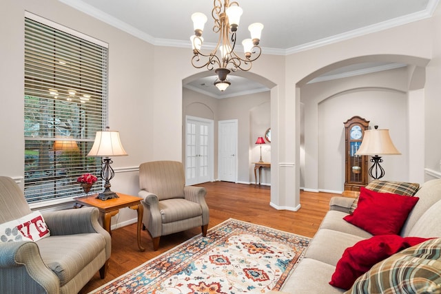 living room featuring hardwood / wood-style flooring, ornamental molding, and a chandelier