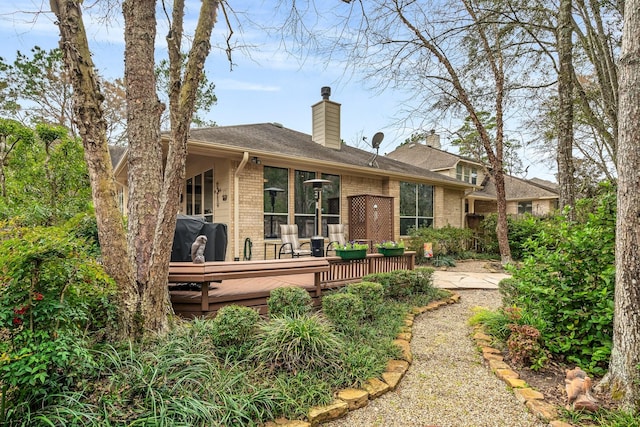 rear view of property featuring a wooden deck