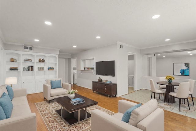 living room with ornamental molding and light wood-type flooring