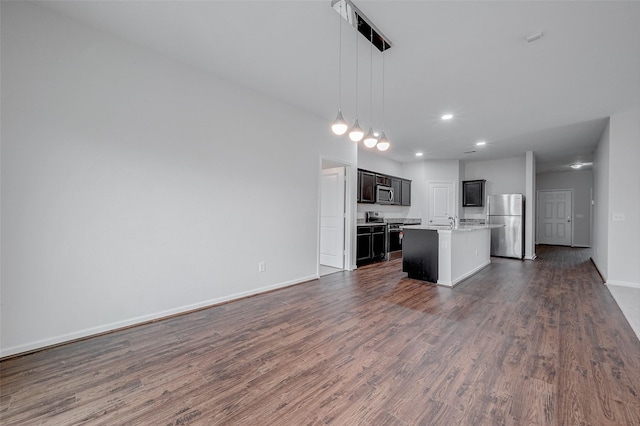 kitchen featuring pendant lighting, sink, dark wood-type flooring, appliances with stainless steel finishes, and a center island