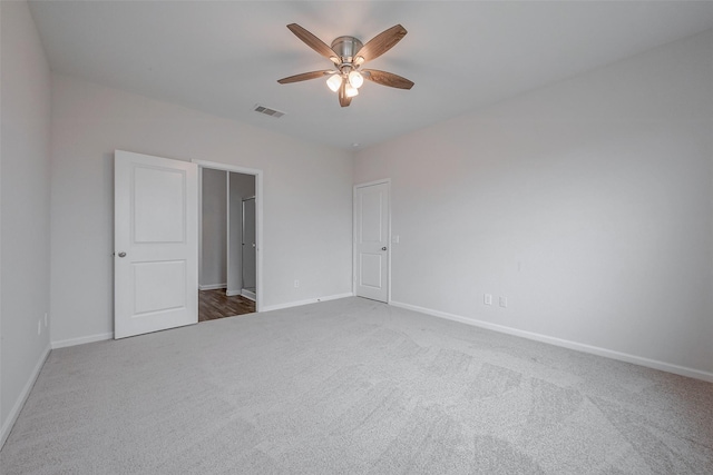 spare room featuring ceiling fan and dark carpet