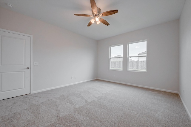 carpeted spare room featuring ceiling fan