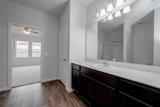 bathroom featuring hardwood / wood-style flooring, ceiling fan, vanity, a shower, and toilet