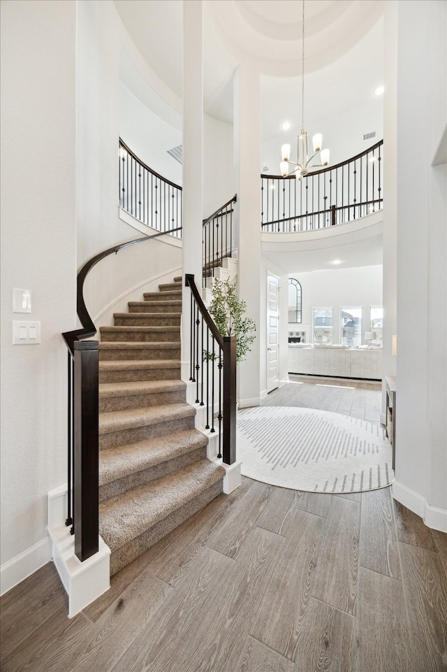 entrance foyer featuring hardwood / wood-style floors, a high ceiling, and a notable chandelier