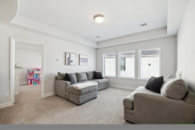 living room with light colored carpet and a tray ceiling