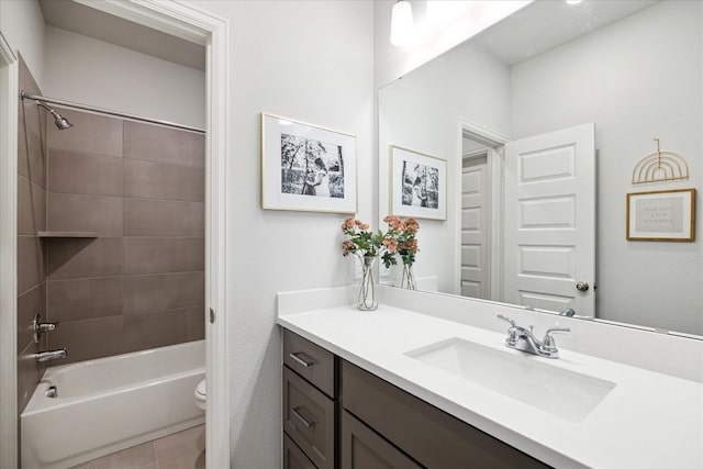 full bathroom featuring vanity, tiled shower / bath combo, tile patterned floors, and toilet