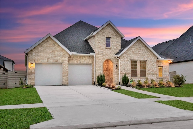 view of front of property featuring a garage and a lawn