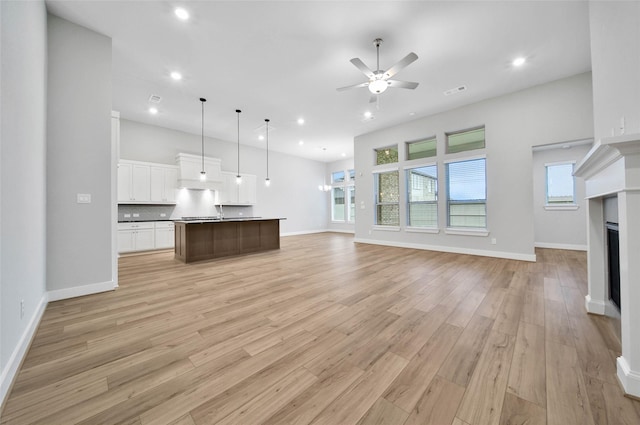 unfurnished living room with ceiling fan and light wood-type flooring