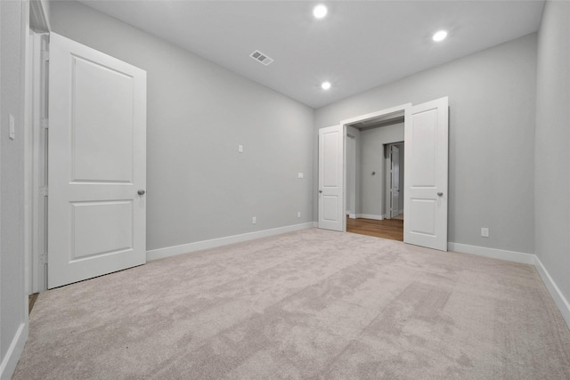 unfurnished bedroom featuring light carpet