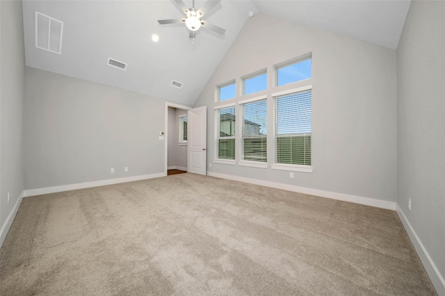 carpeted empty room with ceiling fan and high vaulted ceiling