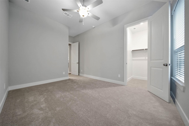 empty room with ceiling fan and light colored carpet