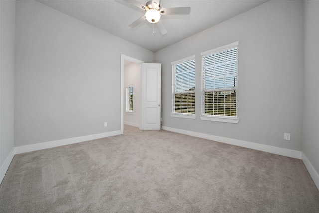 carpeted spare room with ceiling fan