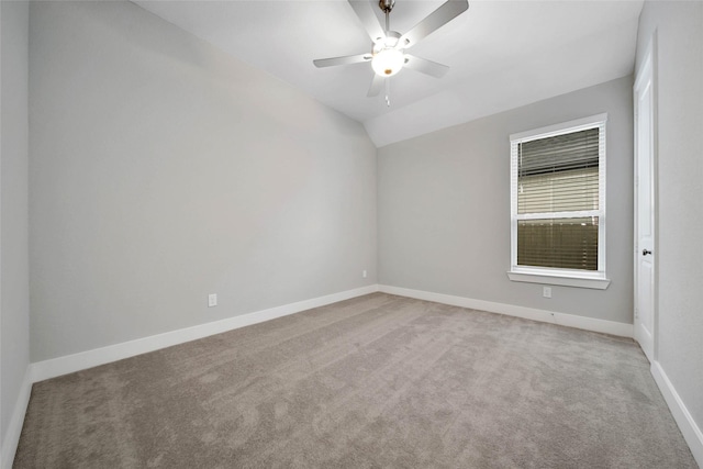 spare room featuring lofted ceiling, ceiling fan, and carpet flooring