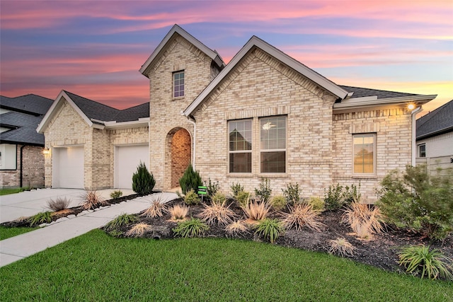 view of front of property with a garage and a yard