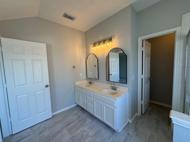 bathroom with vaulted ceiling and vanity