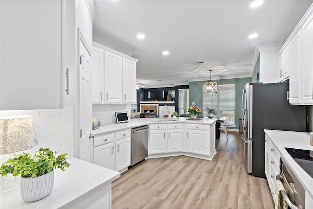 kitchen featuring white cabinetry, appliances with stainless steel finishes, pendant lighting, and kitchen peninsula