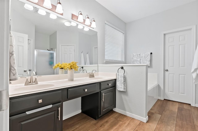 bathroom with vanity, hardwood / wood-style flooring, and plus walk in shower