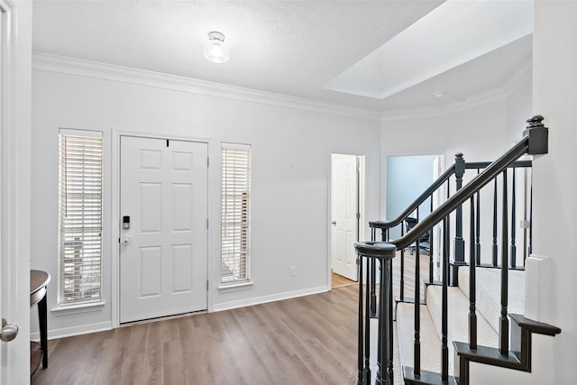 foyer entrance with crown molding and light hardwood / wood-style flooring