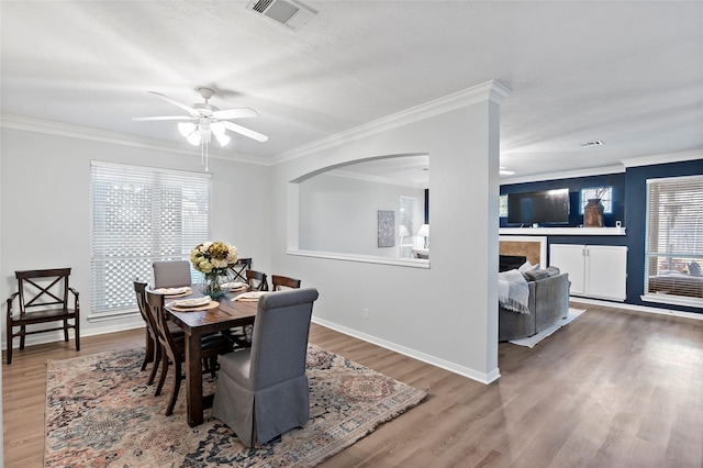 dining room with hardwood / wood-style floors, crown molding, and ceiling fan