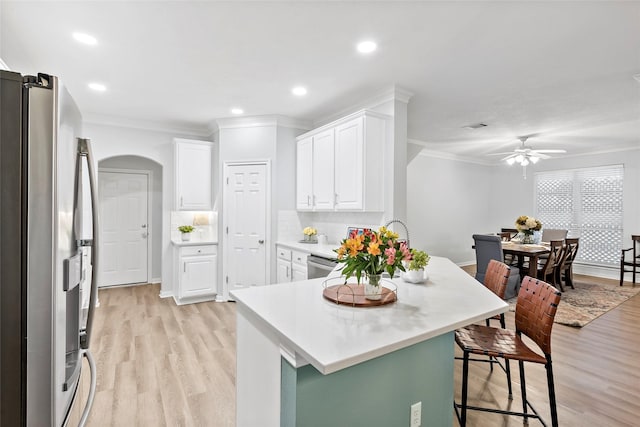 kitchen with crown molding, a breakfast bar, white cabinetry, stainless steel appliances, and kitchen peninsula