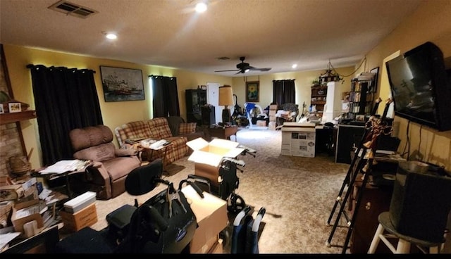 carpeted living room with visible vents, a ceiling fan, and a stone fireplace