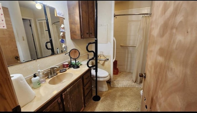 full bath featuring toilet, tile patterned floors, a tile shower, and vanity