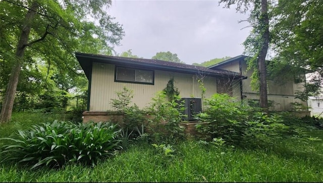 view of side of home with central air condition unit