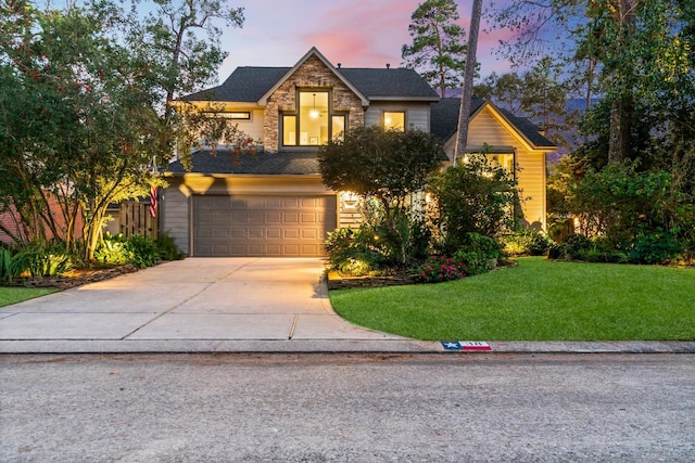 view of front of home with a garage and a lawn