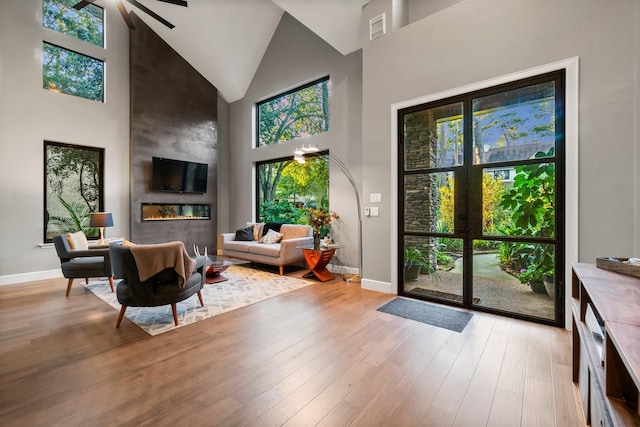 interior space with plenty of natural light, a large fireplace, and light hardwood / wood-style floors