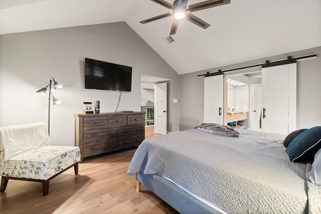 bedroom with light hardwood / wood-style flooring, high vaulted ceiling, a barn door, and ceiling fan