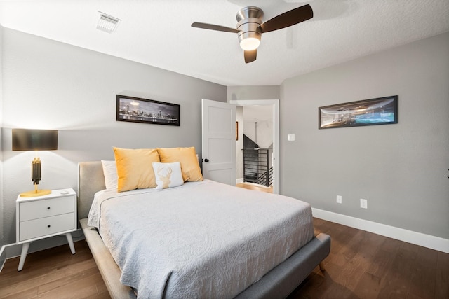 bedroom featuring a textured ceiling, dark hardwood / wood-style floors, and ceiling fan