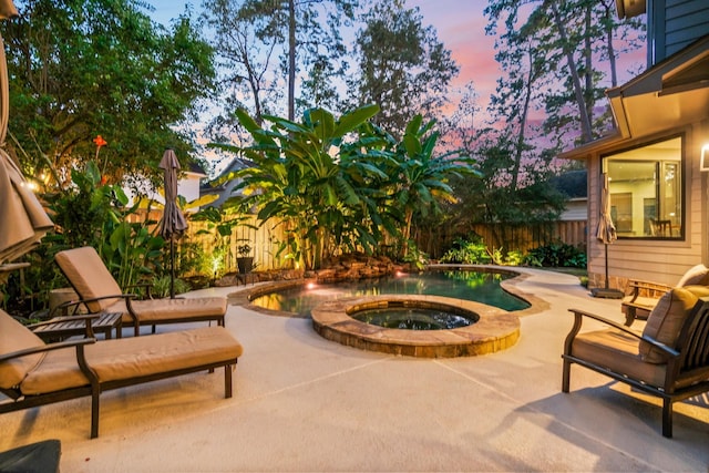 patio terrace at dusk featuring an in ground hot tub