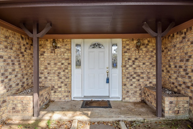 entrance to property featuring brick siding