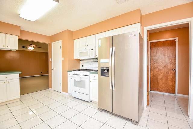 kitchen with light tile patterned floors, white appliances, white cabinetry, and a ceiling fan