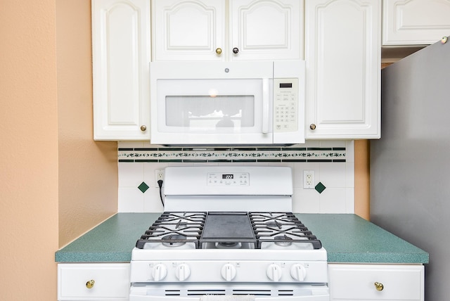 kitchen featuring white cabinetry, white appliances, and backsplash