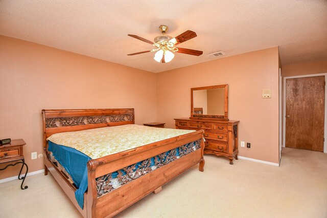 bedroom with baseboards, visible vents, ceiling fan, a textured ceiling, and light carpet