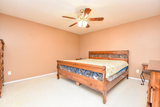 bedroom with a ceiling fan, baseboards, and light carpet