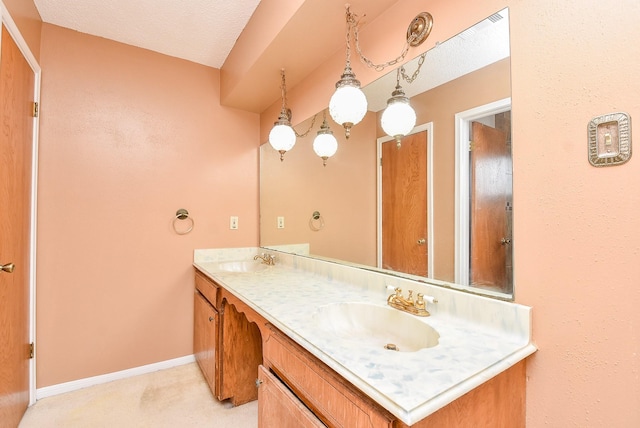 full bathroom featuring a sink, baseboards, and double vanity