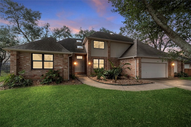 view of front of property with a garage and a lawn