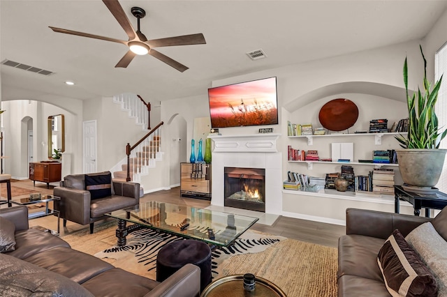 living room featuring hardwood / wood-style flooring, a fireplace, and ceiling fan