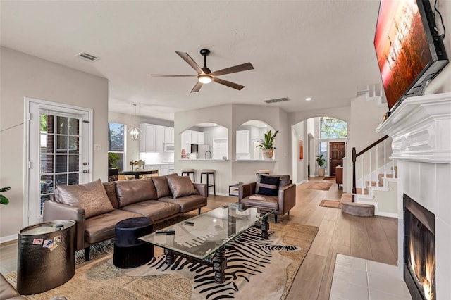 living room with ceiling fan and light hardwood / wood-style flooring