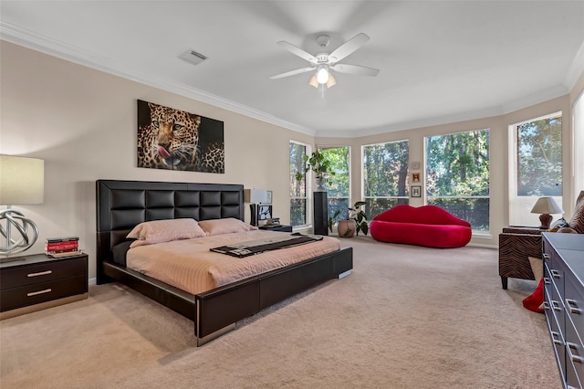 carpeted bedroom with ornamental molding and ceiling fan